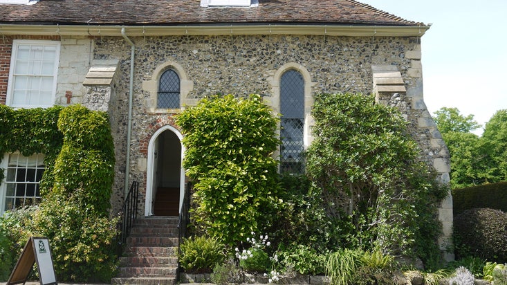 Image of a medieval flint-walled chapel with steps leading up to the entrance